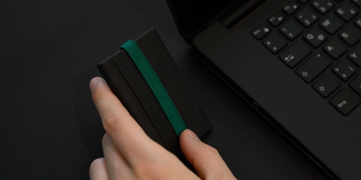 Card Holder mit Münzfach in Kreditkartengröße in Schwarz mit grünem Gummiband.